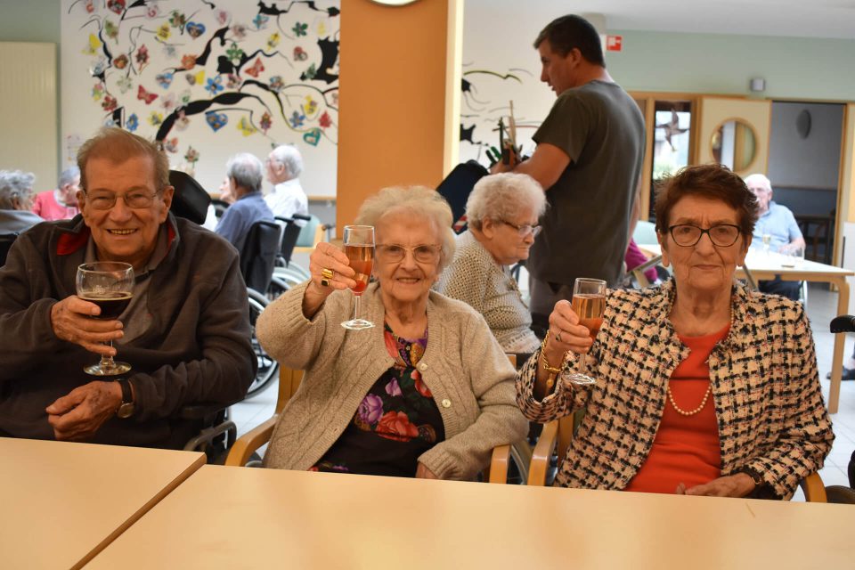 Bewoners heffen samen het glas in de gemeenschappelijke ruimte van het woonzorgcentrum.
